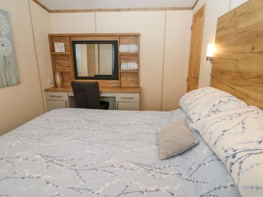 A bedroom with a bed and a desk at Plot 41 High Hesket near Armathwaite