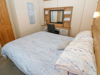 A bedroom with a bed and desk at Plot 41 High Hesket near Armathwaite