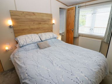 A bedroom with a bed and bedside lamps at Plot 41 High Hesket near Armathwaite