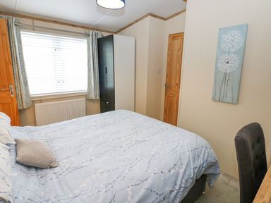 A bedroom with a bed and wardrobe at Plot 41 High Hesket near Armathwaite
