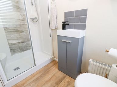 A bathroom with a shower and sink at Plot 41 in High Hesket near Armathwaite