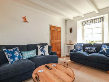 A living room with a sofa and coffee table at Stones Throw in Mevagissey
