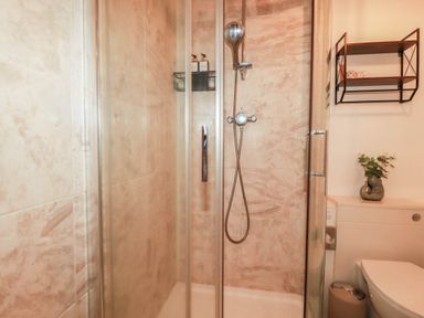 A shower with glass doors in a bathroom at Stones Throw in Mevagissey
