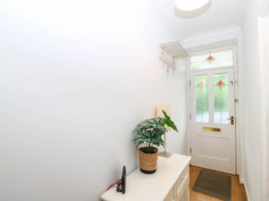 A hallway with a plant and console table at Llys Awen Caernarfon