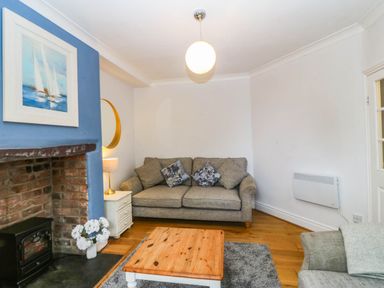 A living room with a sofa and coffee table at Llys Awen in Caernarfon