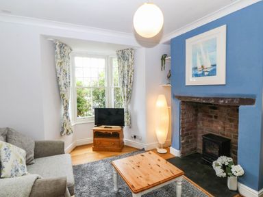 A living room with a sofa and television at Llys Awen in Caernarfon