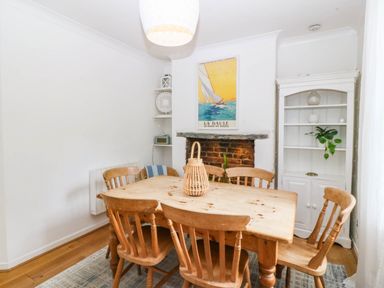 A dining room with a wooden table and chairs at Llys Awen in Caernarfon
