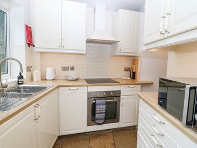 A kitchen with cabinets and appliances at Llys Awen in Caernarfon