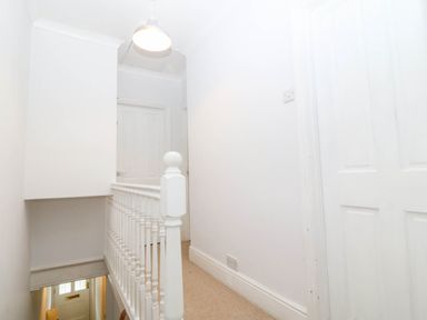A hallway with a staircase and doors at Llys Awen in Caernarfon
