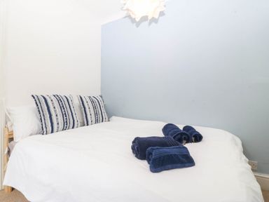 A bedroom with a bed and towels at Llys Awen Caernarfon