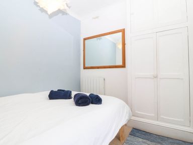 A bedroom with a bed and towels at Llys Awen Caernarfon