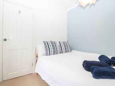 A bedroom with a bed and a door at Llys Awen in Caernarfon
