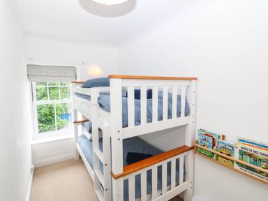 A bedroom with a bunk bed and a shelf of books at Llys Awen Caernarfon