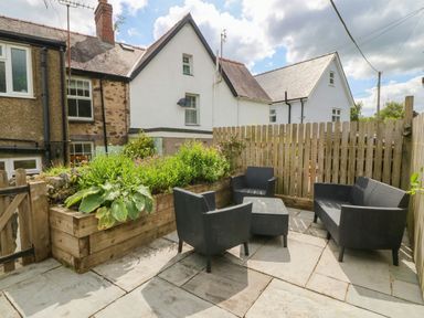 A garden with seating and a plant bed at Llys Awen in Caernarfon