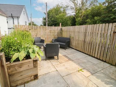 A garden with outdoor seating and flowers at Llys Awen Caernarfon
