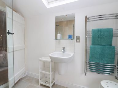 A bathroom with a sink and towels on a rail at 19 Covert Road in Reydon