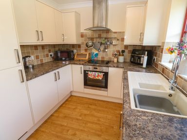 A kitchen with cabinets and appliances at Yonde View in Camborne