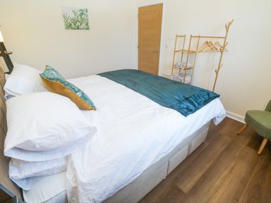 A bedroom with a bed and coat rack at Yonde View in Camborne