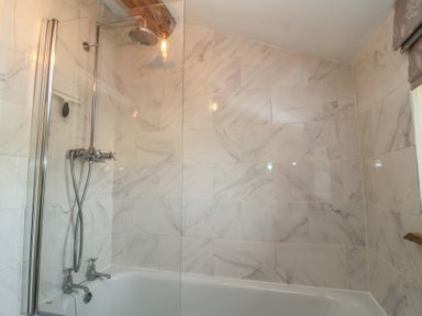 A bathroom with a shower and bathtub at 2 The Gardens in Lechlade