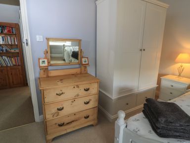 A bedroom with a dresser and a wardrobe at 2 The Gardens in Lechlade