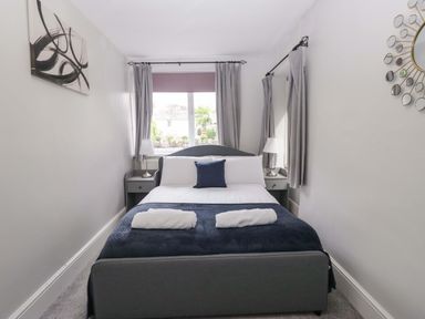 A bedroom with a bed and bedside tables at Courtyard Cottage Cartmel
