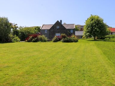 A house with garden and trees at Mayfly Cottage