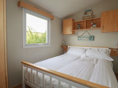 A bedroom with a bed and shelf at Tucked Away in Newquay