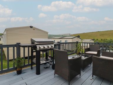 An outdoor area with a barbeque grill and seating at Tucked Away in Newquay