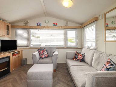 A living room with a sofa and television at Tucked Away in Newquay