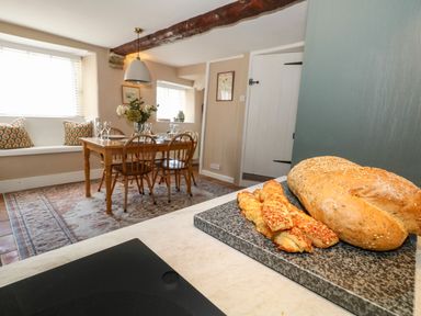 A dining room with a table and chairs at Little Wickers in Corfe Castle