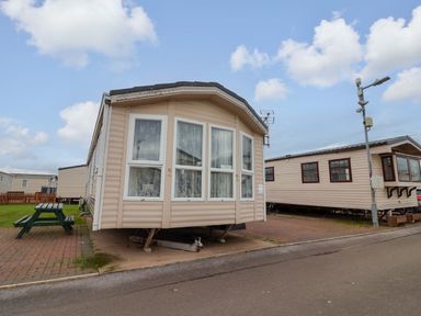 A mobile home with large windows and a porch in a residential area at Winchester - 478 Abergele