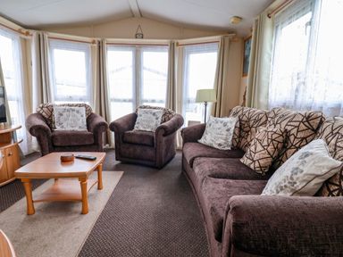 A living room with seating and a coffee table at Winchester - 478 Abergele
