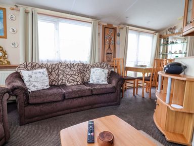 A living room with a sofa and dining table at Winchester - 478 Abergele