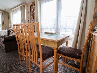A dining room with a table and chairs at Winchester - 478 in Abergele