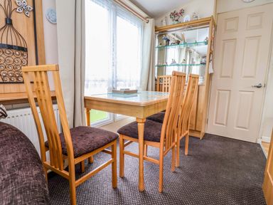 A dining room with a table and chairs at Winchester - 478 Abergele