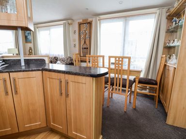 A dining room with a table and chairs at Winchester - 478 Abergele