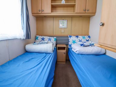 A bedroom with two beds and a bedside table at Winchester - 478 in Abergele