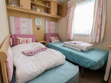 A bedroom with two beds with pink bedding and stuffed animals at Winchester - 478 Abergele