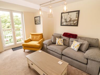 A living room with a sofa and armchair at Twyni Bach