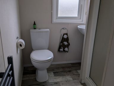 A bathroom with a toilet and sink at Presthaven - Denbigh Dunes in Gronant
