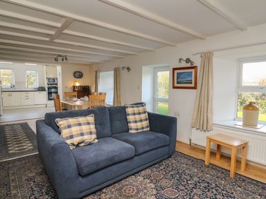 A living room with a sofa and table at Tegfan in Newport