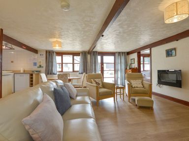 A living room with sofa, chairs, and a table at Pillhead Cart Linhay in Bideford