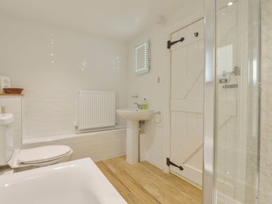 A bathroom with a bathtub, toilet, and sink at Pillhead Cart Linhay in Bideford