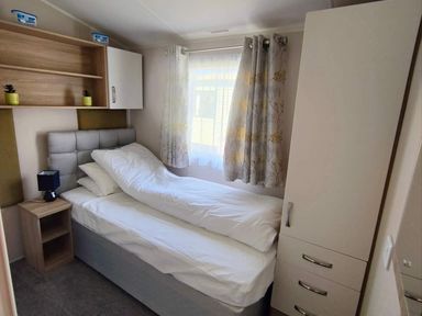 A bedroom with a bed and nightstand at Clarach Bay Holiday Village W18 Aberystwyth