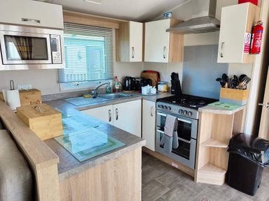 A kitchen with appliances and cabinets at Clarach Bay Holiday Village W18 Aberystwyth