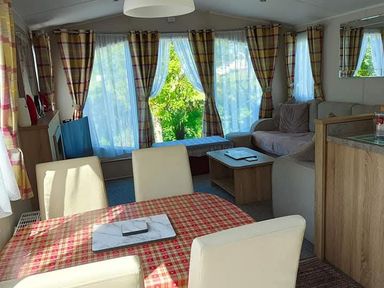 A living room with a dining table and sofa at Clarach Bay Holiday Village W18 Aberystwyth