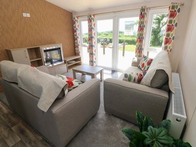 A living room with sofas and a television at Sandpiper in Narberth