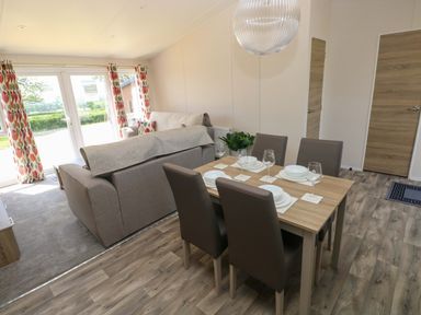 A living room with a sofa and dining table at Sandpiper in Narberth