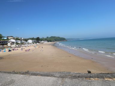 A beach with people and tents near houses at Sandpiper in Narberth