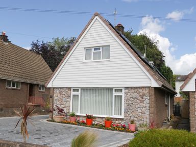 A house with a stone exterior and garden at Halsdon Avenue Exmouth